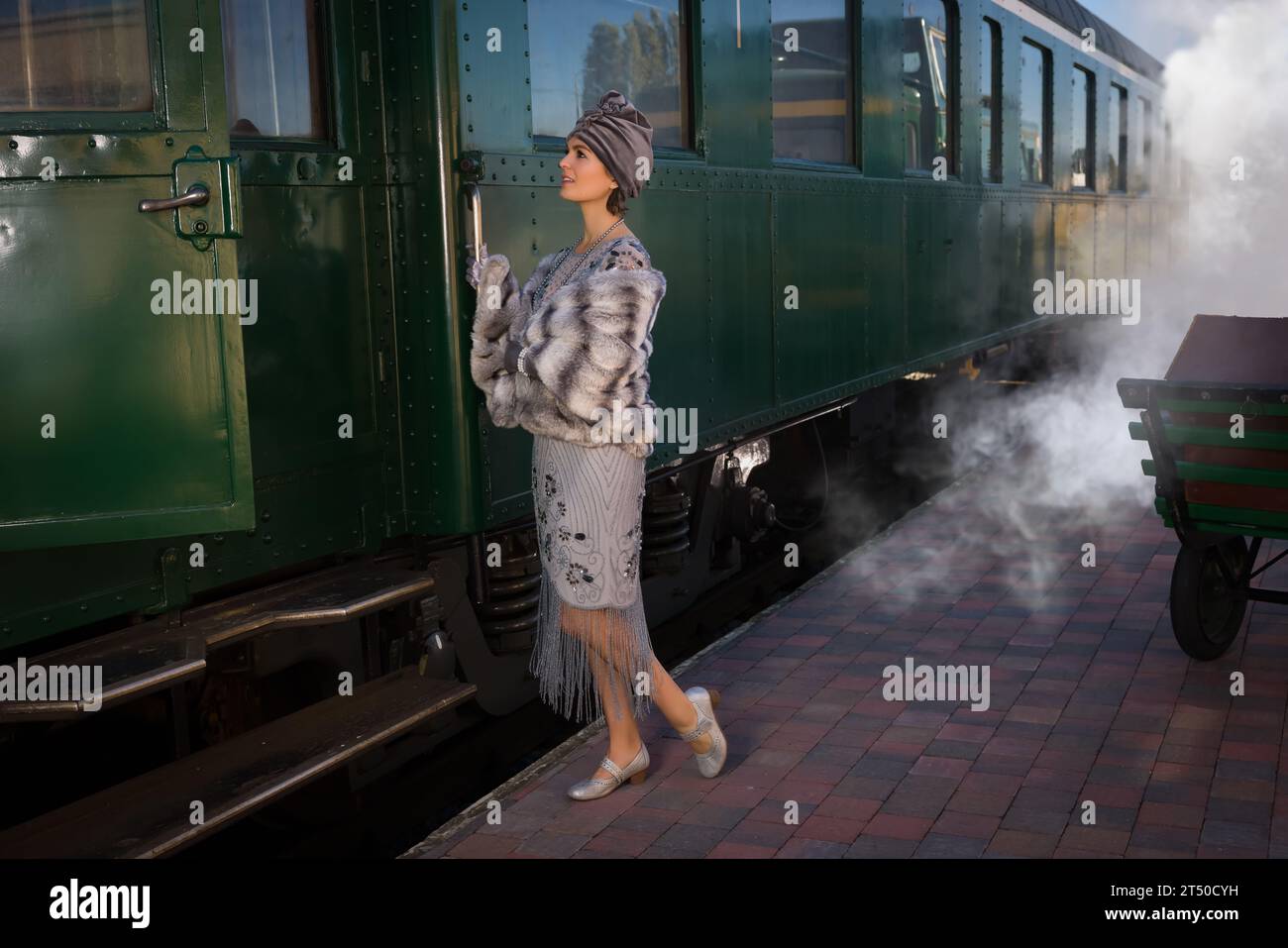 Costume da dama in costume anni '1920 in attesa del treno a vapore su una piattaforma del treno Foto Stock