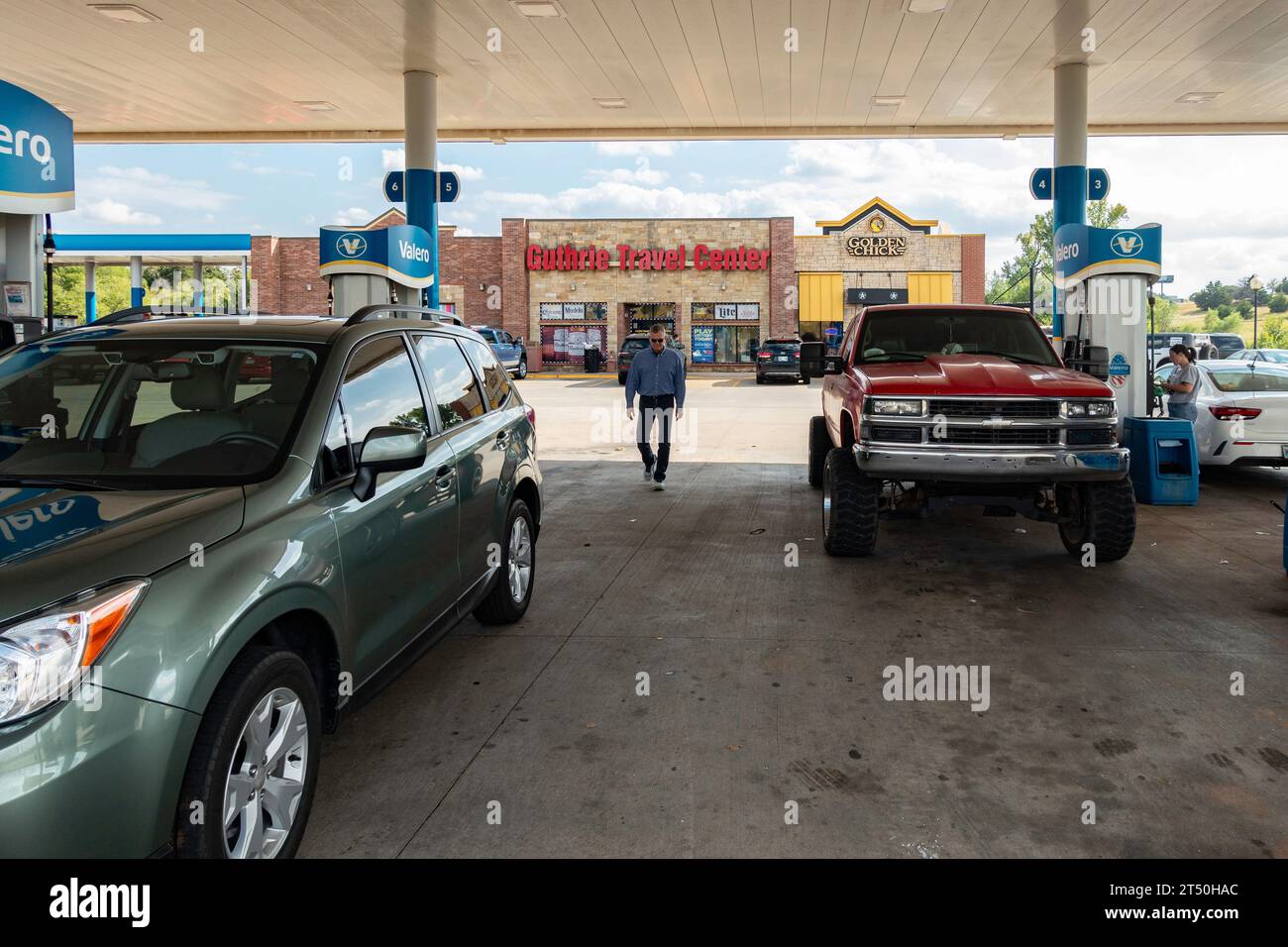 Un uomo di 60 anni cammina verso la sua auto dopo aver pagato la benzina al Guthrie Travel Center, Guthrie, Oklahoma, USA Foto Stock