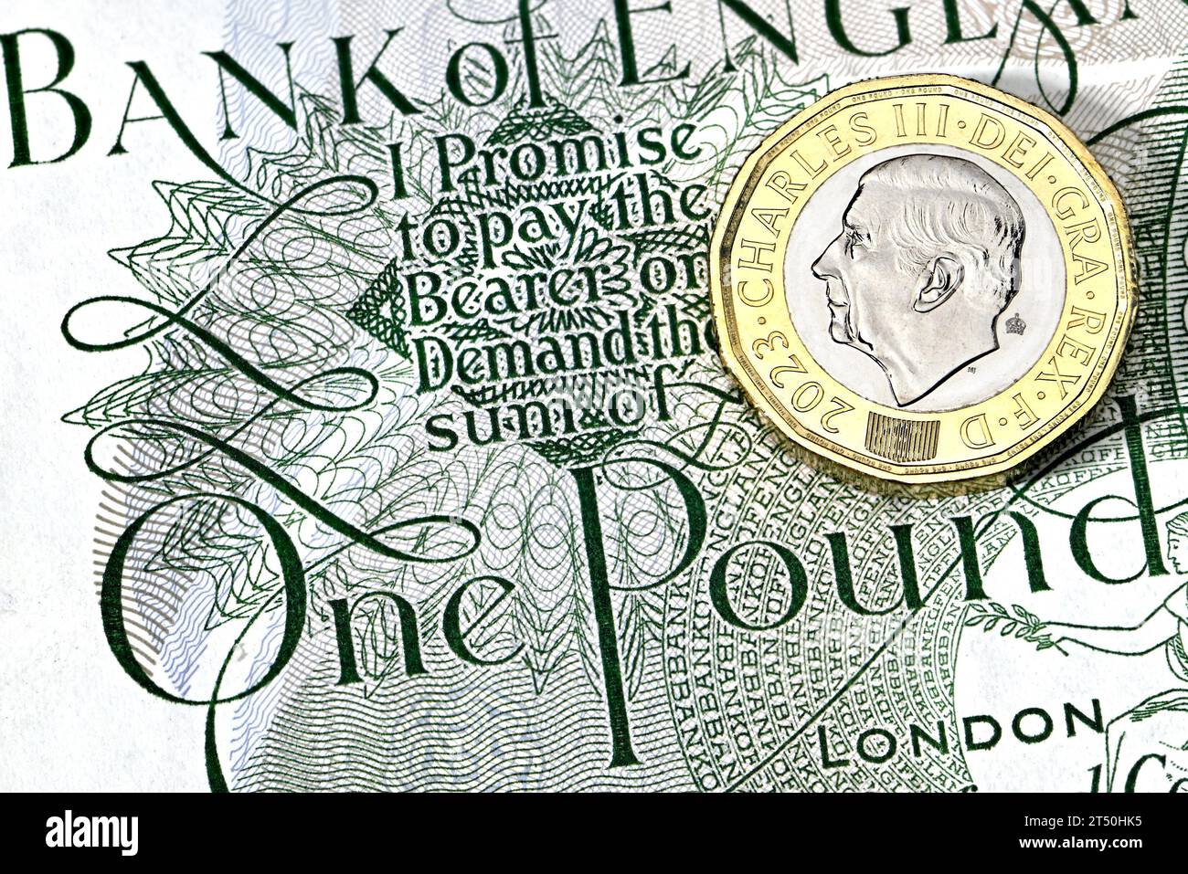 Nuovo re britannico Carlo III moneta da £1 su una vecchia banconota da £1 Foto Stock