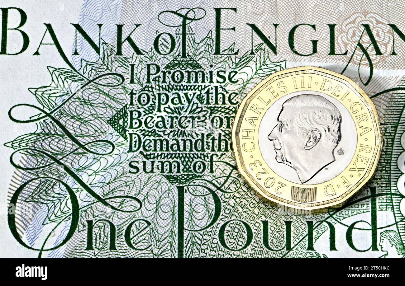 Nuovo re britannico Carlo III moneta da £1 su una vecchia banconota da £1 Foto Stock