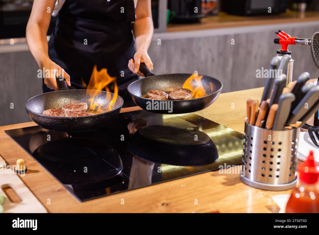 Hamburger di carne o tortino a forma di cotoletta che vengono fritti poco a poco in olio su una padella Foto Stock