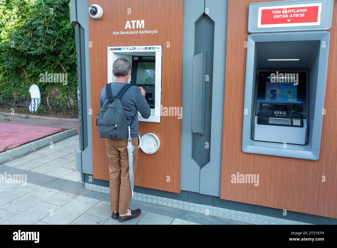 Istanbul, Turchia, Un uomo che nasconde soldi in un bancomat in strada. Solo editoriale. Foto Stock