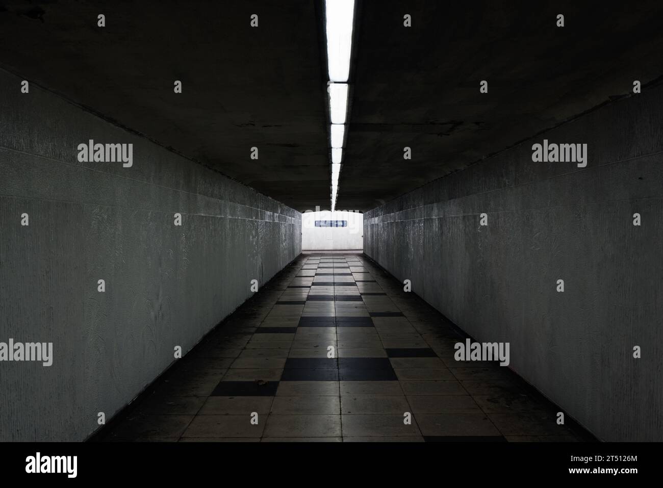 Birmingham, West Midlands, Regno Unito: Una vista simmetrica di un sottopassaggio pedonale deserto del Queensway con illuminazione lungo il soffitto e pavimento piastrellato. Foto Stock