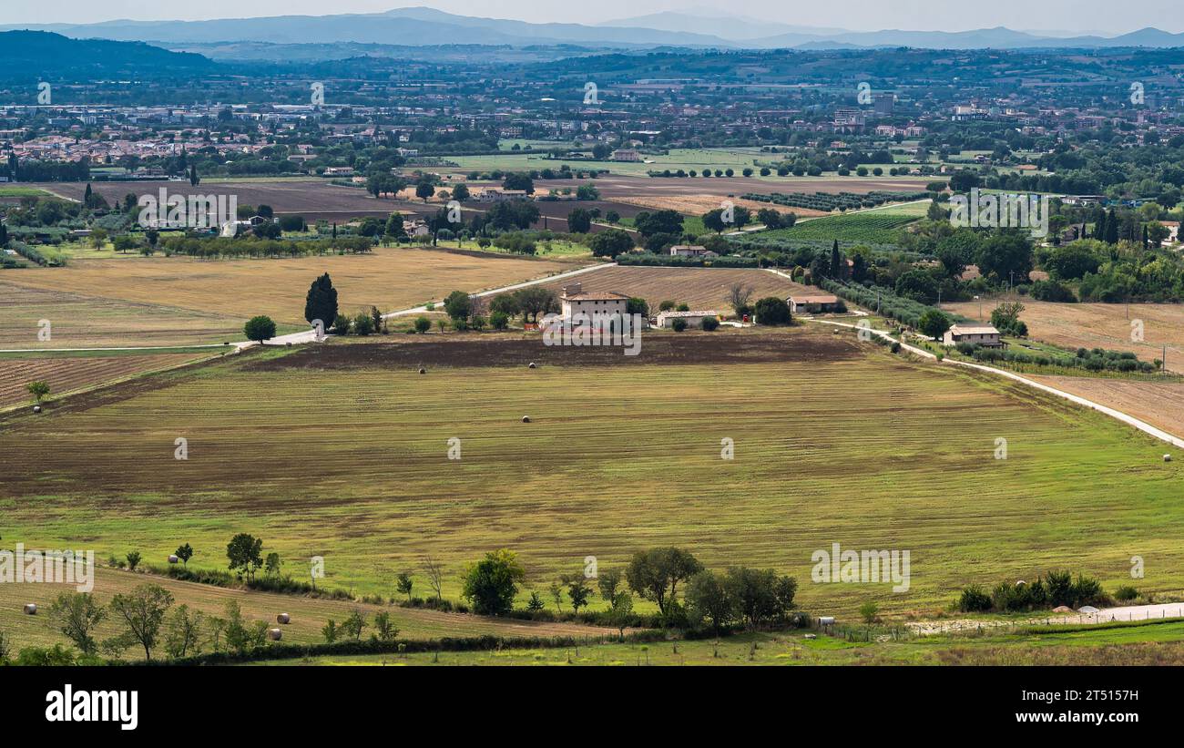 Una foto che si affaccia sui lussureggianti campi verdi che circondano Assisi in Umbria, Italia. Foto Stock