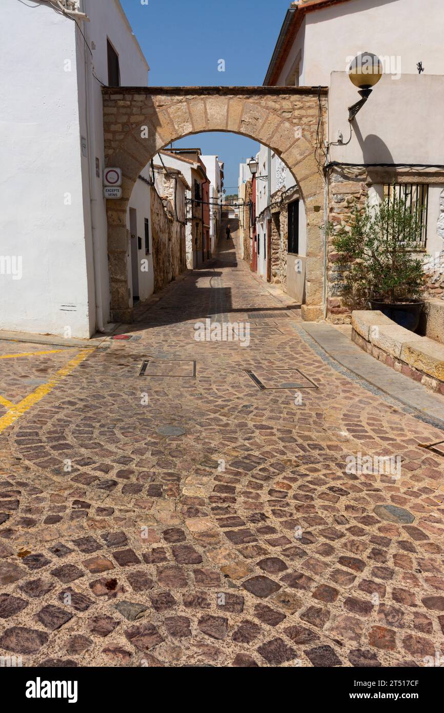 Sagunto, Valencia, Spagna. 30 agosto 2022 - Vecchia porta d'accesso al quartiere ebraico della città, situata accanto al teatro romano. Pavimento piastrellato in pietra Foto Stock