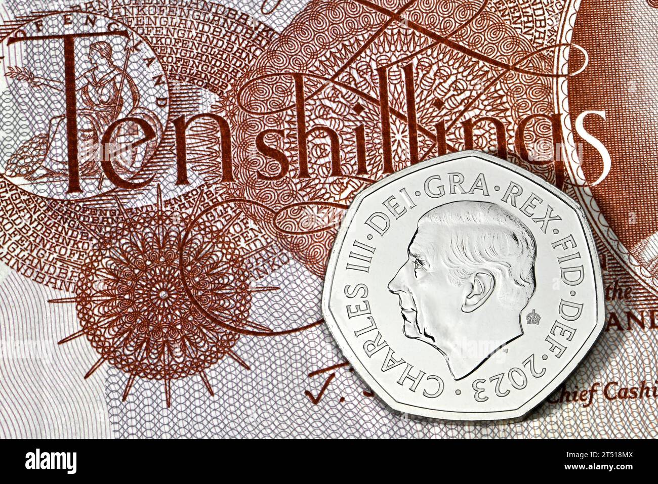 Nuova moneta britannica Charles III 50p su una vecchia banconota da dieci Shilling (equivalente) Foto Stock