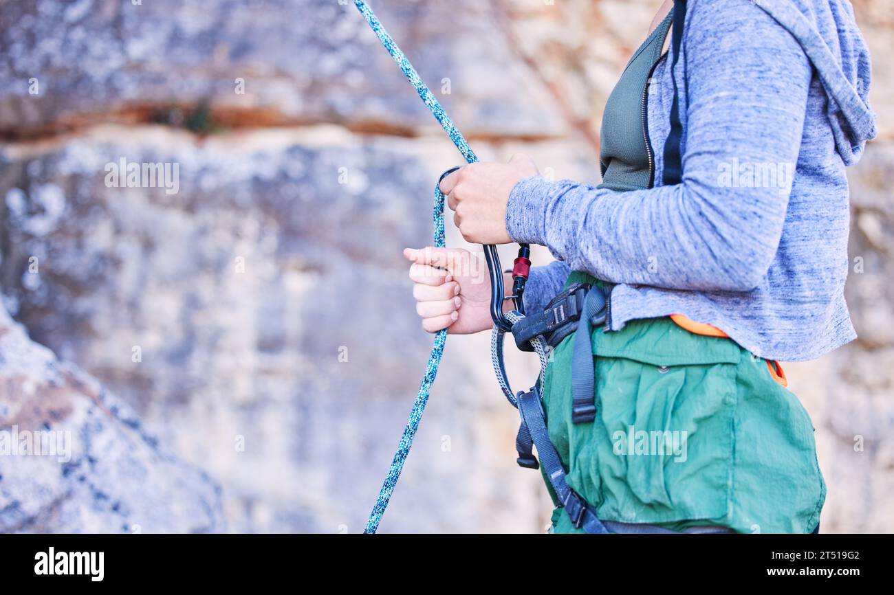 Arrampicata su roccia, montagna e mani di donna con corda per avventura, libertà e sport estremi. Fitness, persona esterna e donna con sicurezza Foto Stock