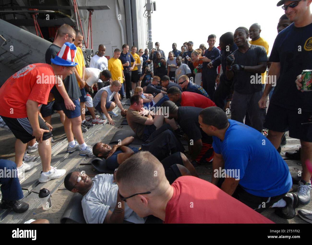 110704DU438-186 GOLFO PERSICO (4 luglio 2011) i marinai partecipano a una gara sit-up durante una celebrazione del giorno dell'indipendenza a bordo dell'incrociatore missilistico guidato USS Gettysburg (CG 64). Gettysburg è in programma per supportare le operazioni di sicurezza marittima e gli sforzi di cooperazione per la sicurezza del teatro nell'area di responsabilità della 5th Fleet degli Stati Uniti. Marina Foto Stock