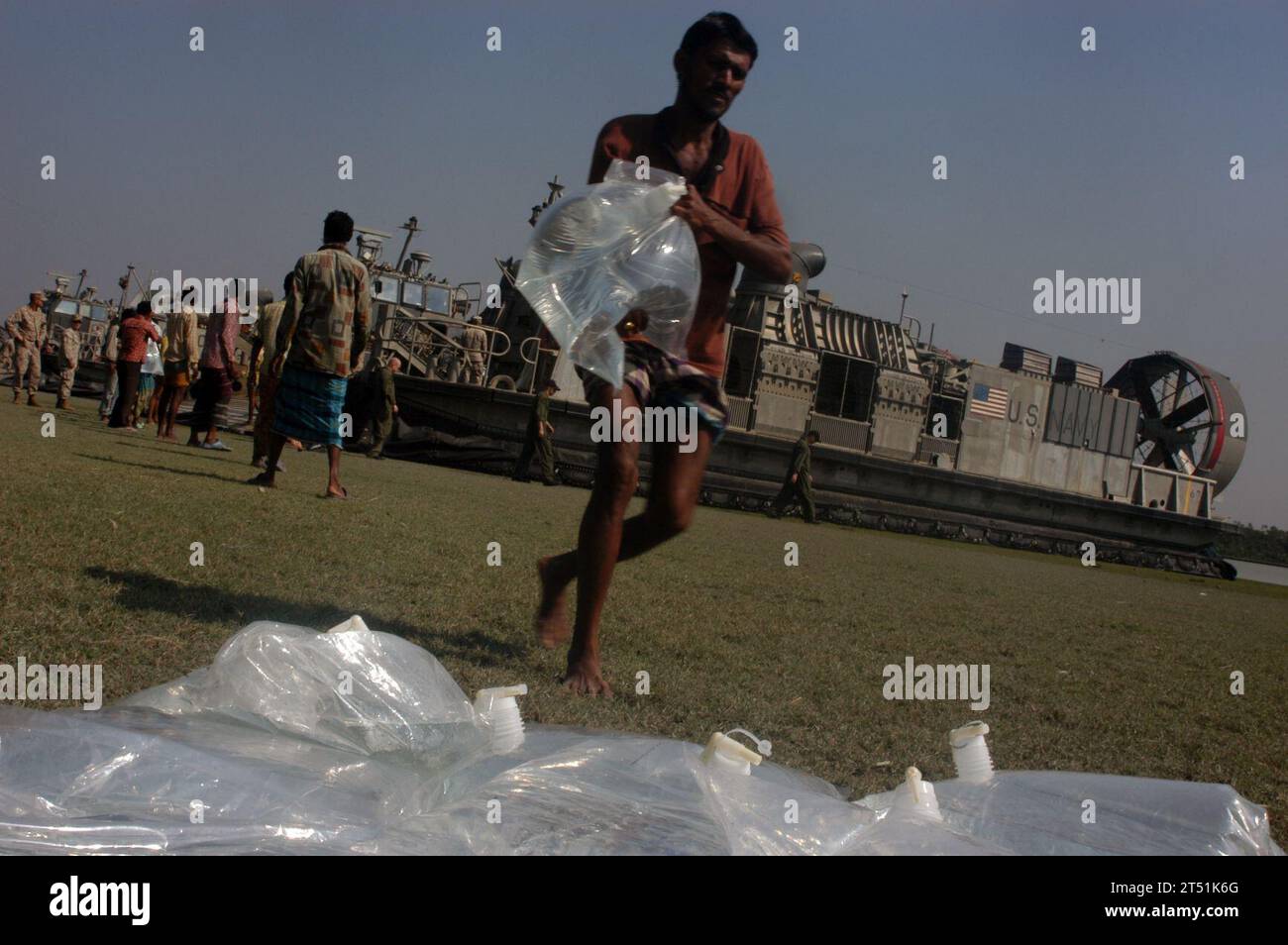 0711285642P-047 KALAPARA, BANGLADESH (29 novembre 2007) - persone di Kalapara, Bangladesh aiutano a scaricare sacchi d'acqua da un cuscino d'aria per imbarcazioni da atterraggio (LCAC) dall'unità 4 dell'Assault Craft attualmente attaccata alla nave d'assalto anfibio USS Kearsarge (LHD 3). La nave d'assalto anfibio USS Kearsarge (LHD 3) e la 22nd Marine Expeditionary Unit (Special Operations Capable) stanno conducendo sforzi di assistenza umanitaria/soccorso in caso di catastrofi in risposta alla richiesta di assistenza del governo del Bangladesh dopo che il ciclone tropicale Sidr ha colpito la loro costa meridionale 15 novembre. La tempesta è finita Foto Stock