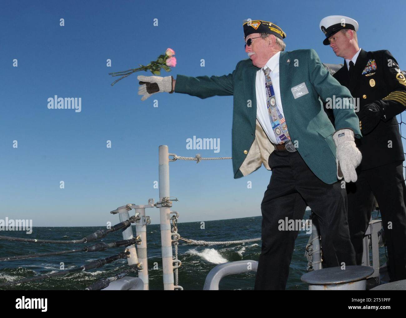 1012075812W-001 MAYPORT, Flag. (7 dicembre 2010) il veterano della marina Bobby Smith, a sinistra, lancia rose nell'oceano mentre il capo del comando Matt Miesle lo preferisce durante una cerimonia di Pearl Harbor Day a bordo della fregata missilistica guidata USS Underwood (FFG 36). La cerimonia commemorò il 69° anniversario dell'attacco giapponese a Pearl Harbor del 7 dicembre 1941. Marina Foto Stock