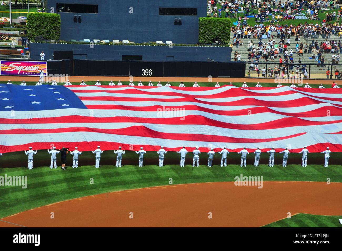 1009112953W-336 SAN DIEGO (11 settembre 2010) i marinai assegnati alla portaerei USS Carl Vinson (CVN 70) svelano la "Pacific Life Holiday Bowl Big Flag" durante le attività pre-partita al PETCO Park per commemorare il nono anniversario degli attacchi terroristici dell'11 settembre 2001 a New York e Washington. Marina Foto Stock