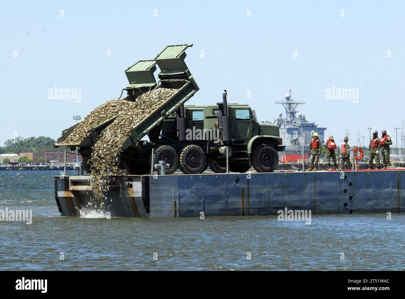 1004283154P-149 VIRGINIA BEACH, VIRGINIA (28 aprile 2010) marinai assegnati all'Amphibious Construction Battalion (ACB) 2, scarta gusci di ostriche nelle distese di fango di Little Creek Cove per stabilire due nuove barriere coralline artificiali di ostriche. Le ostriche sono l'ostrica orientale naturale, Crassostrea virginica, che può filtrare 50 galloni d'acqua individualmente ogni giorno. Marina Foto Stock