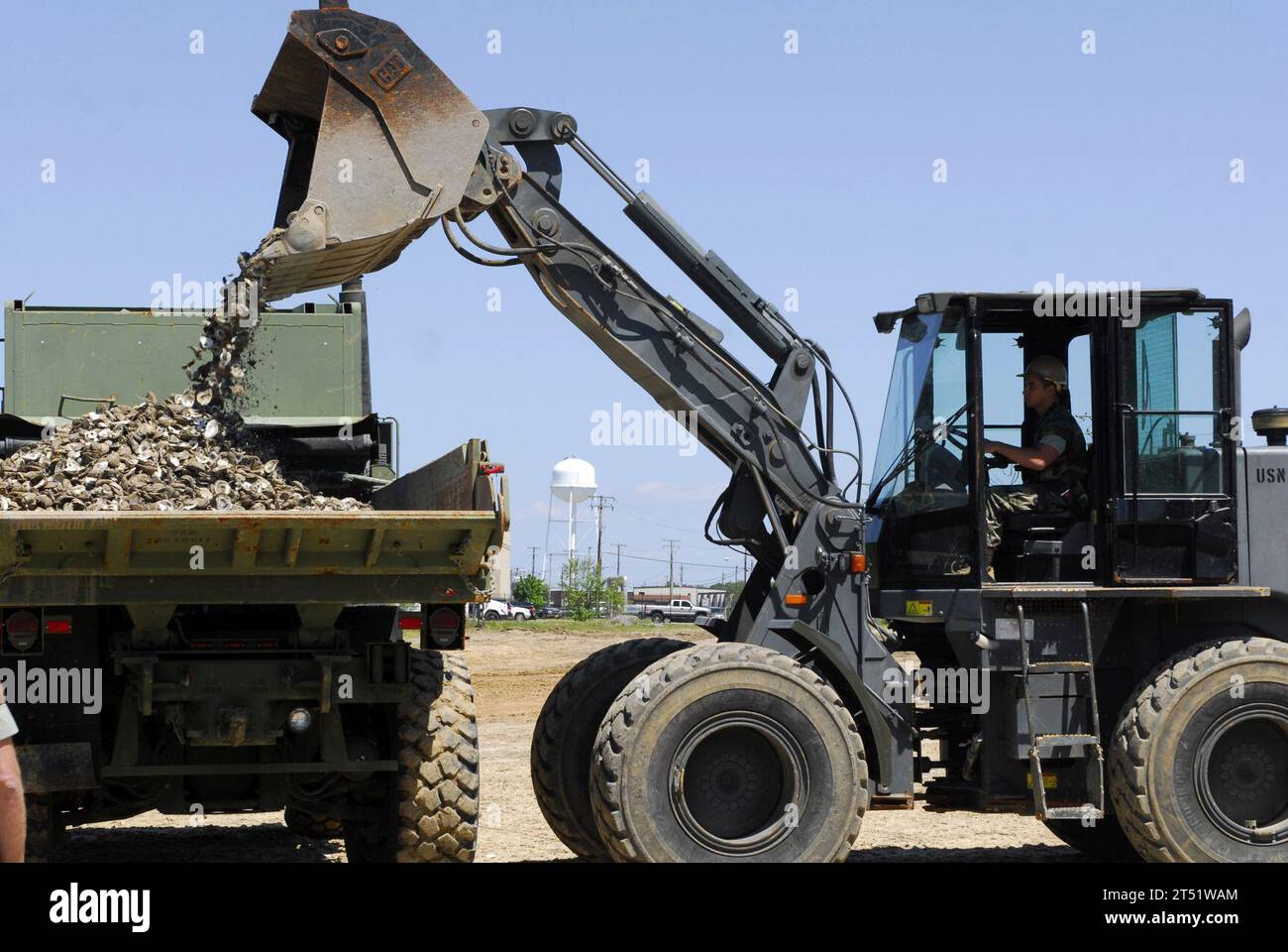1004283154P-123 VIRGINIA BEACH, VIRGINIA (28 aprile 2010) i marinai assegnati all'Amphibious Construction Battalion (ACB) 2, usano macchinari pesanti per caricare conchiglie di ostriche per due nuovi siti artificiali di barriera corallina nelle distese di fango di Little Creek Cove. Le ostriche sono l'ostrica orientale naturale, Crassostrea virginica, che può filtrare 50 galloni d'acqua individualmente ogni giorno. Marina Foto Stock