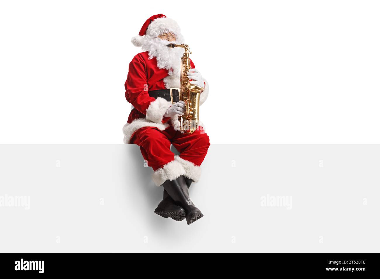 Babbo Natale che suona il sassofono e si siede su una parete bianca Foto Stock
