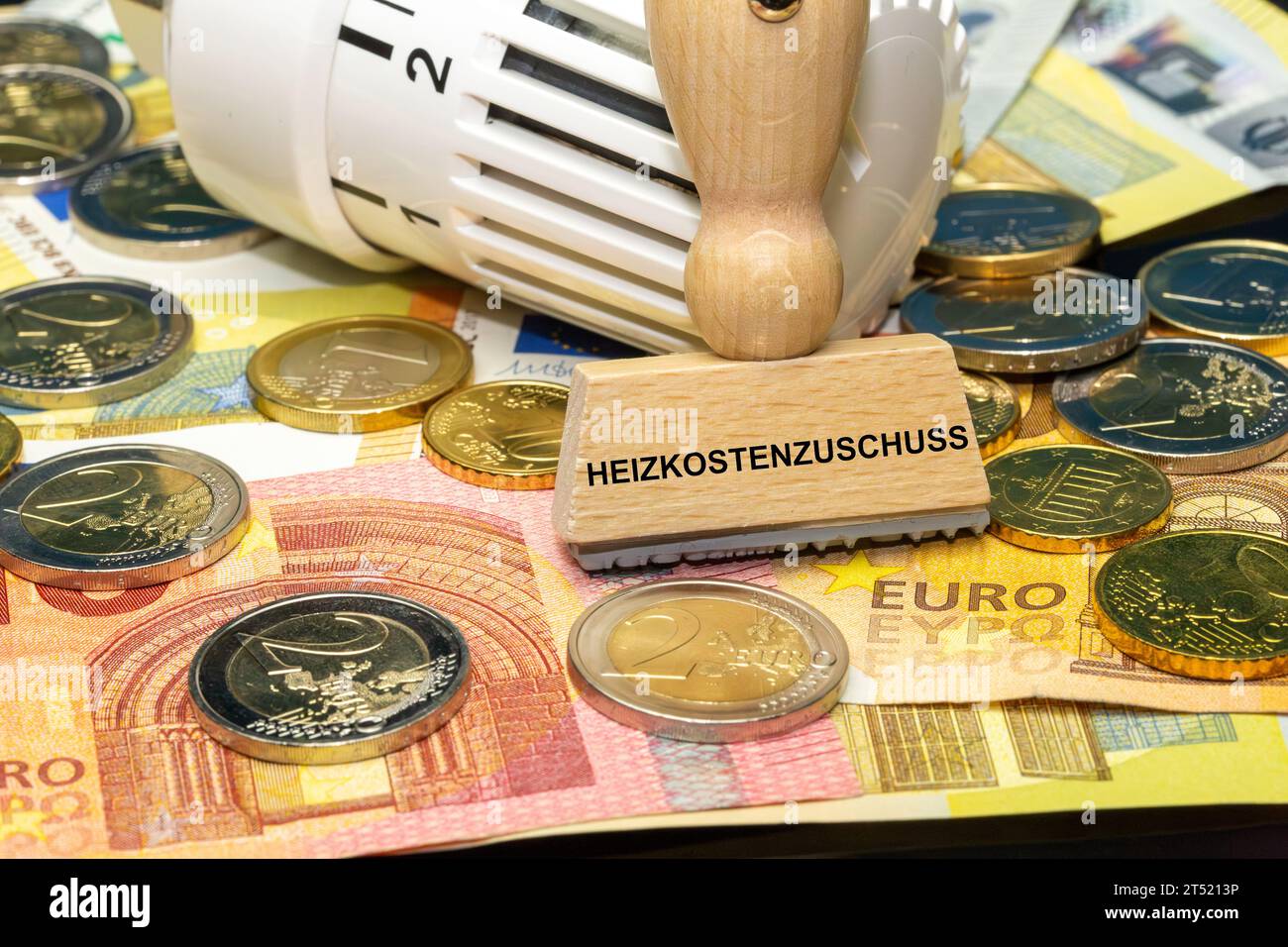 Termostato sulle banconote e sulle monete in euro e timbro con la scritta tedesca Heizkostenzuschuss (riduzione dei costi di riscaldamento) Foto Stock