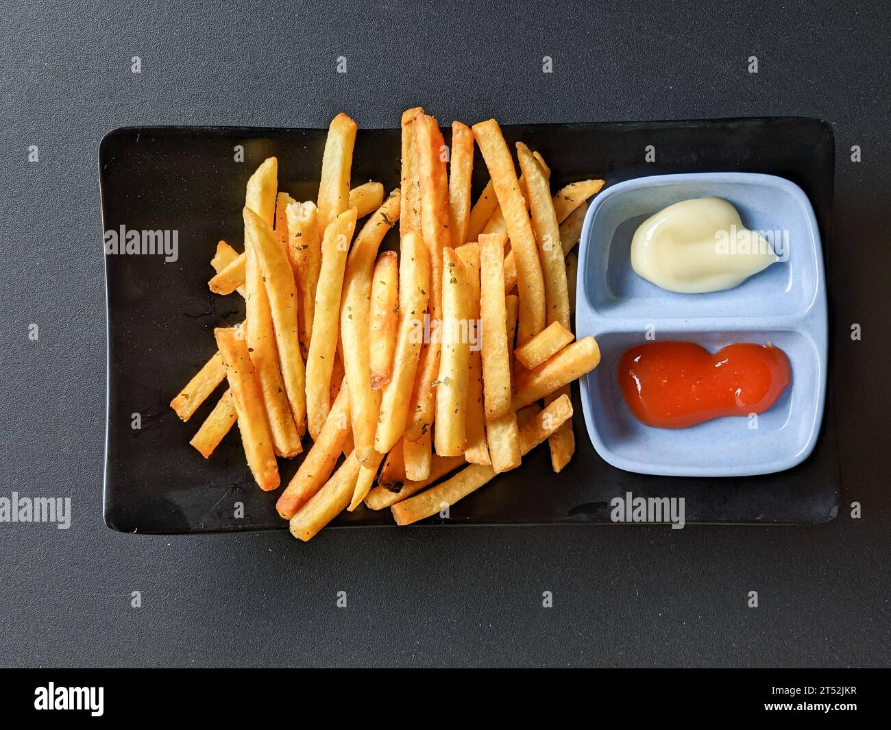 patatine fritte con salsa e maionese su sfondo nero. vista dall'alto Foto Stock