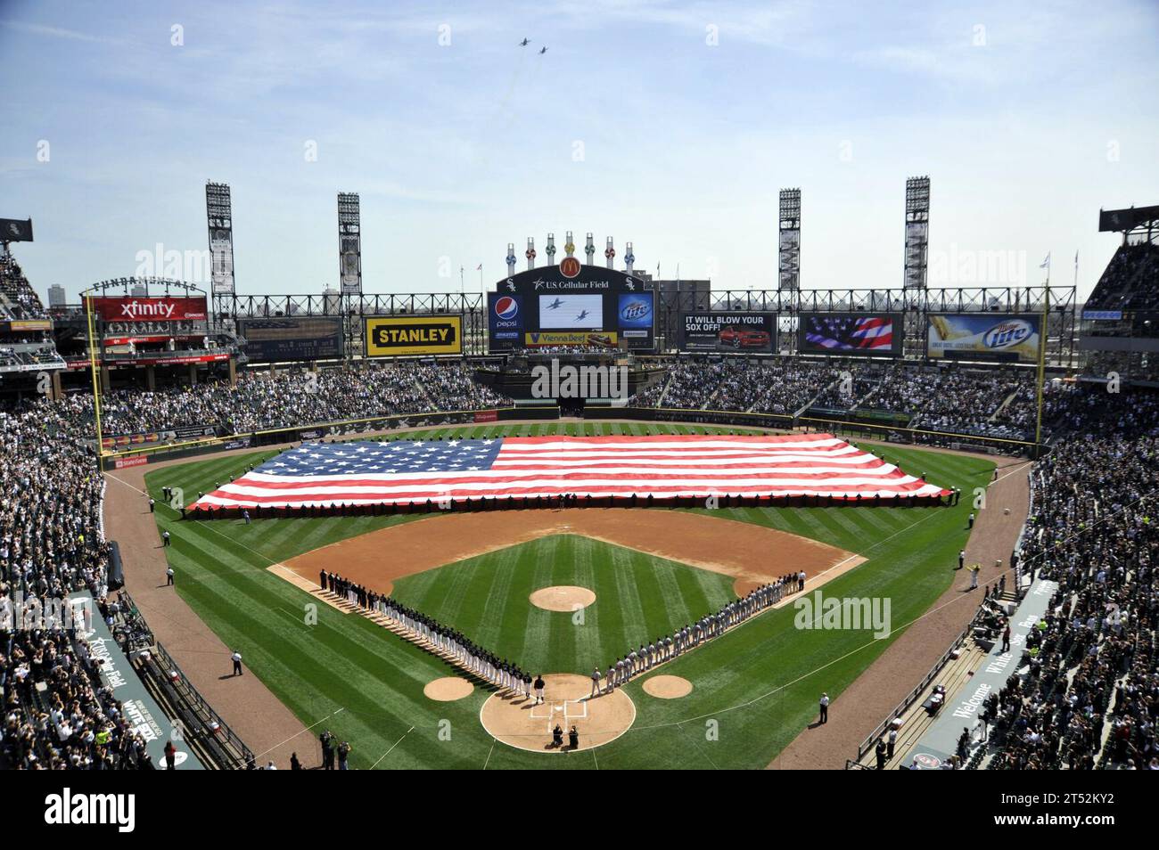 1004061232M-001 CHICAGO (6 aprile 2010) i marinai assegnati a vari comandi alla Naval Station Great Lakes svelano una bandiera americana prima della partita di baseball casalinga di apertura dei Chicago White Sox del 2010 allo U.S. Cellular Field. Marina Foto Stock