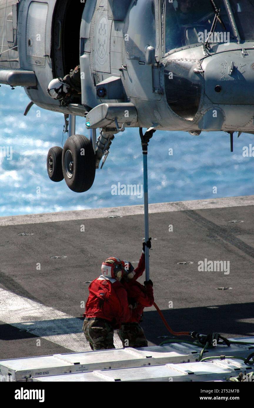 0704051635S-002 SOUTH CHINA SEA (5 aprile 2007) - Aviation Ordnancemen attaccano il ciondolo su un'imbracatura di sollevamento al gancio esterno di un HH-60H Seahawk, dei "Black Knights" dell'Helicopter Anti-Submarine Squadron (HS) 4, durante un'evoluzione di offload di munizioni sul ponte di volo della USS Ronald Reagan (CVN 76). Gli Ordnancemen dell'aviazione scaricarono oltre 126 bombole di munizioni durante l'evoluzione con la nave da munizioni Military Sealift Command (MSC) USNS Flint (T-AE 32). Il Ronald Reagan Carrier Strike Group è in corso per un'ondata di dispiegamento a sostegno delle operazioni militari statunitensi nel Wes Foto Stock