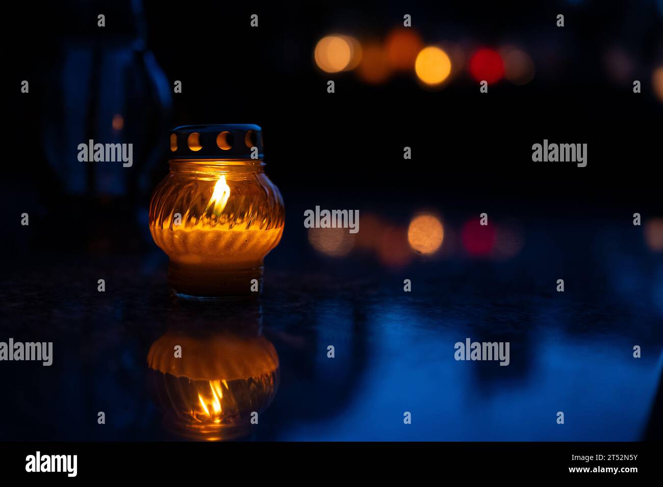 Lume di candela al buio con sfondo bokeh sfocato. Candele nel cimitero di notte. Messa a fuoco selettiva. Profondità di campo bassa. Tutto il giorno del santo. Foto Stock