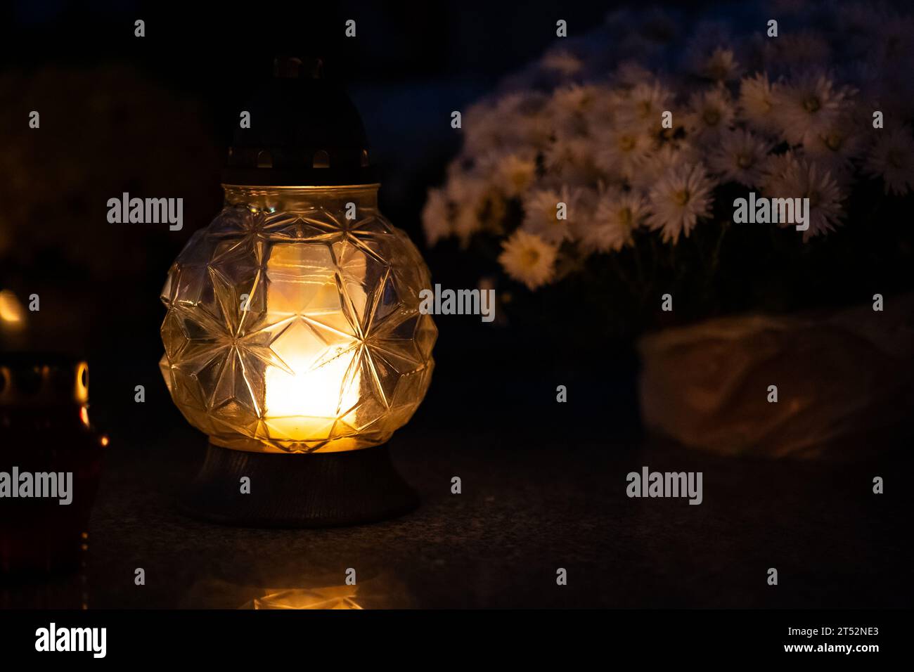 Lume di candela al buio con sfondo bokeh sfocato. Candele nel cimitero di notte. Messa a fuoco selettiva. Profondità di campo bassa. Tutto il giorno del santo. Foto Stock