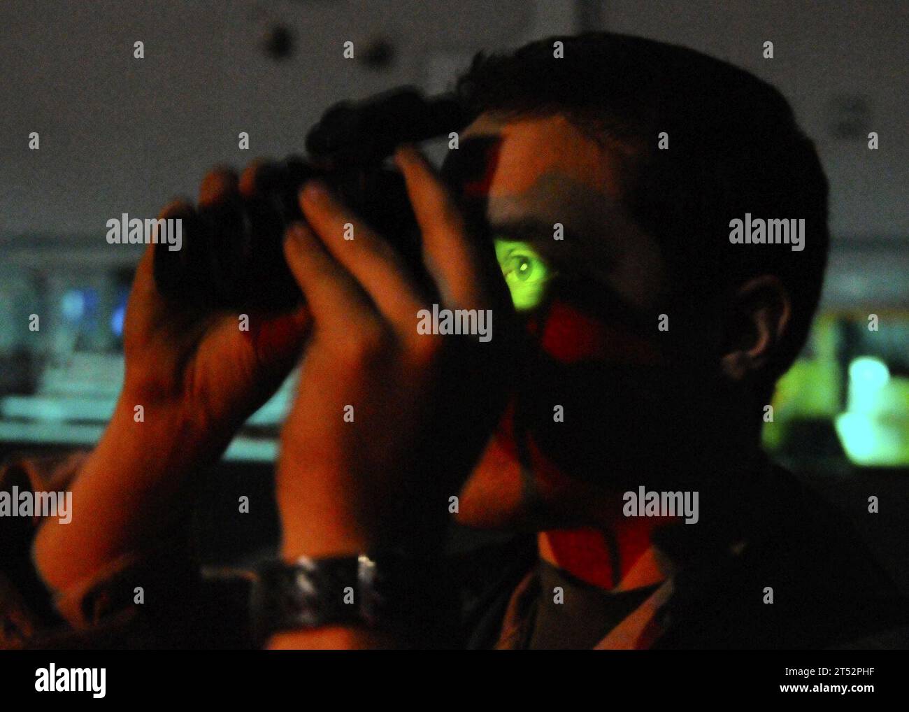 1103193154P-261 MAR MEDITERRANEO (19 marzo 2011) Naval Air Crewman di seconda classe Jordan Lochmann, assegnato all'Helicopter Sea Combat Squadron (HSC) 22, utilizza un binocolo con visione notturna per scansionare l'orizzonte per le tracce missilistiche Tomahawk dal ponte di volo della nave d'assalto anfibio USS Kearsarge (LHD 3) durante le missioni di sciopero a sostegno dell'operazione Odyssey Dawn. La Joint Task Force Odyssey Dawn è la task force statunitense Africa Command istituita per fornire il comando e il controllo operativo e tattico delle forze militari statunitensi, sostenendo la risposta internazionale ai disordini in Libia e l'applicazione della United Foto Stock