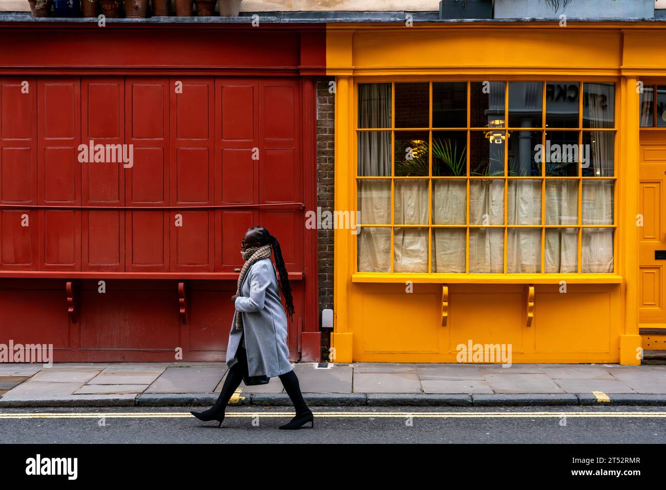 Una donna cammina davanti ad una struttura colorata in Bermondsey Street, Bermondsey, Londra, Regno Unito Foto Stock