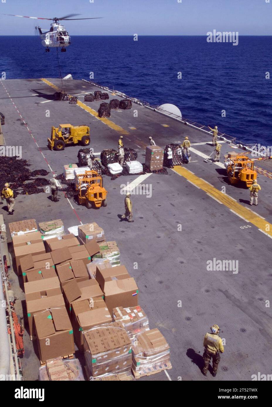 0810255253W-017 SOUTH CHINA SEA (25 ottobre 2008) un elicottero SA330J Puma abbassa un pallet di provviste al ponte di volo della nave d'assalto anfibio USS Essex (LHD 2) mentre marinai e marines spostano i magazzini sotto i ponti durante un rifornimento in corso con la nave cargo USNS Richard E. Byrd (T-AKE 4) del comando militare Sealift. La Essex è la nave guida dell'unico gruppo di attacco della spedizione statunitense schierato in avanti. Foto Stock