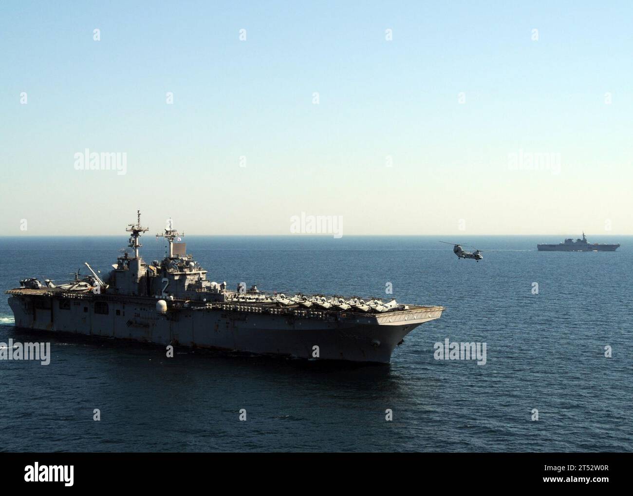 1104060120A-434 PACIFIC OCEAN (6 aprile 2011) Un elicottero CH-46E Sea Knight decolla dal ponte di volo della nave d'assalto anfibio schierata in avanti USS Essex (LHD 2) mentre la nave JS Hyuga (DDH 181) transita sullo sfondo. L'Essex e la 31st Marine Expeditionary Unit (31st MEU) imbarcati operano al largo delle coste di Kesenuma a sostegno dell'operazione Tomodachi. Foto Stock