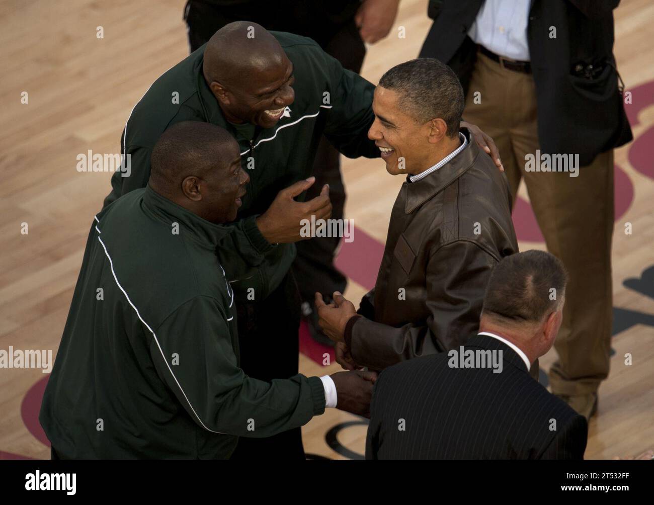 111111DR144-701 SAN DIEGO (11 novembre 2011) il presidente Barack Obama, a sinistra, viene accolto sul campo dal giocatore di basket NBA Hall of Fame Earvin "Magic" Johnson, Center, e dall'assistente allenatore della Michigan State University Mike Garland al Quicken Loans Carrier Classic a bordo della portaerei classe Nimitz USS Carl Vinson (CVN 70). Carl Vinson ha ospitato la Michigan State University e la University of North Carolina per una partita di pallacanestro NCAA. Foto Stock