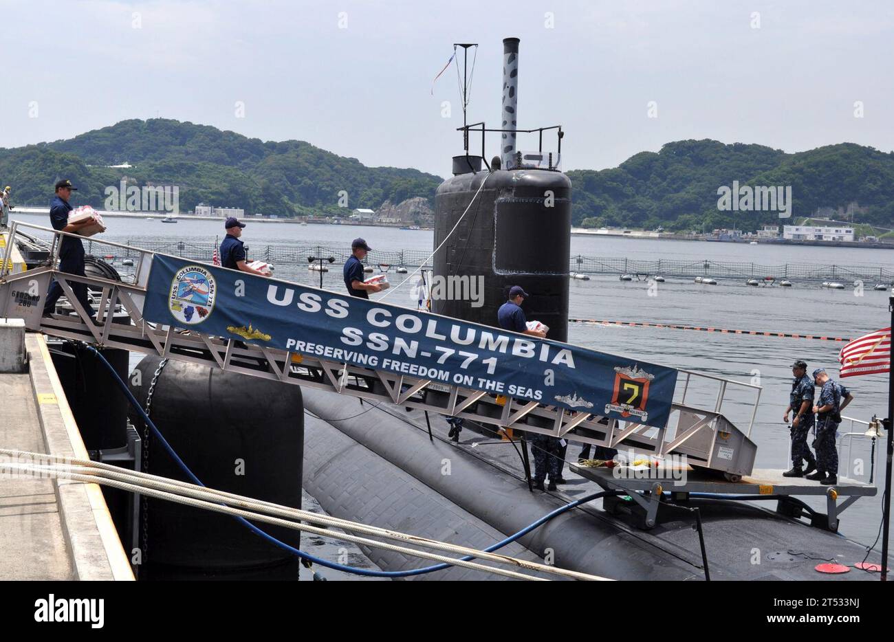 110701DI599-016 YOKOSUKA, Giappone (1 luglio 2011) i marinai assegnati al sottomarino d'attacco della classe Los Angeles USS Columbia (SSN 771) caricano i depositi poco dopo l'ormeggio alla Fleet Activities Yokosuka. La Columbia sta visitando Yokosuka durante un dispiegamento nella regione occidentale del Pacifico. Foto Stock