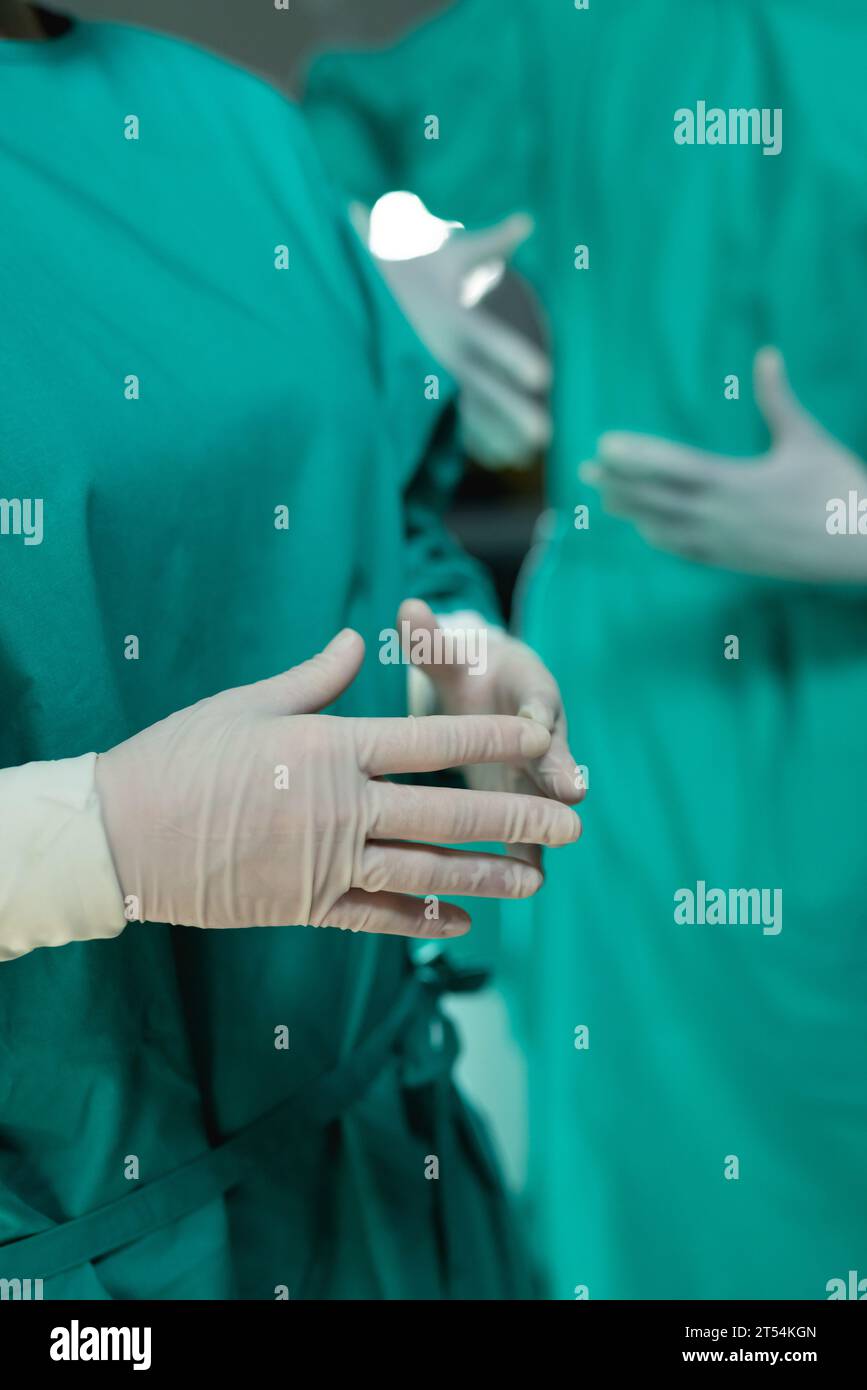 Sezione intermedia di diversi chirurghi che indossano abiti chirurgici in sala operatoria all'ospedale Foto Stock