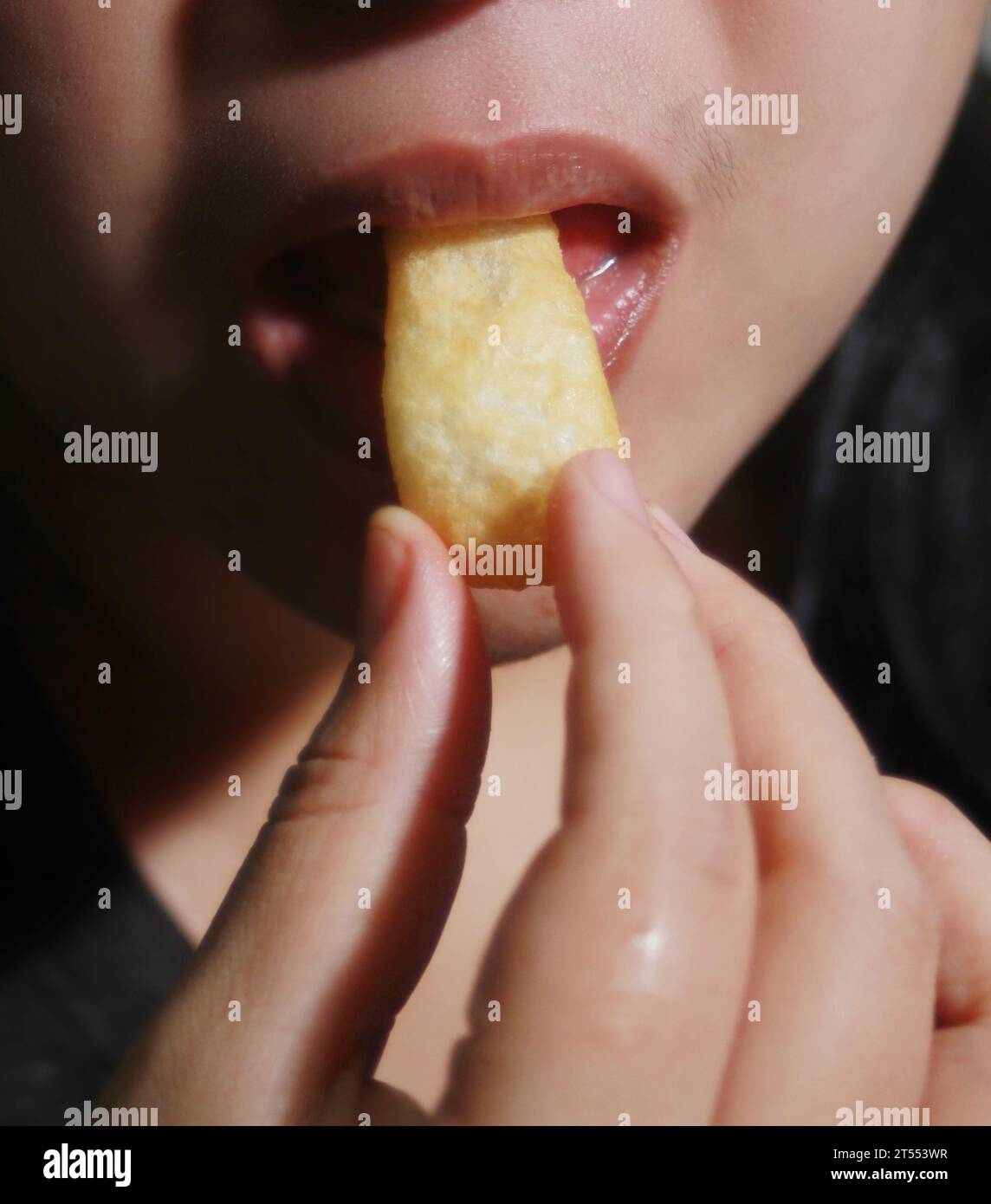 Donna che mangia pasticcini croccanti, è un popolare cibo di strada che è delizioso e si trova comunemente in paesi asiatici come Thailandia, Cina, Laos, Vietn Foto Stock