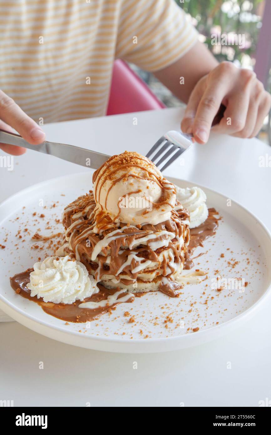 Uomini che mangiano pancake con gelato in un ristorante caffetteria e caffetteria. Foto Stock