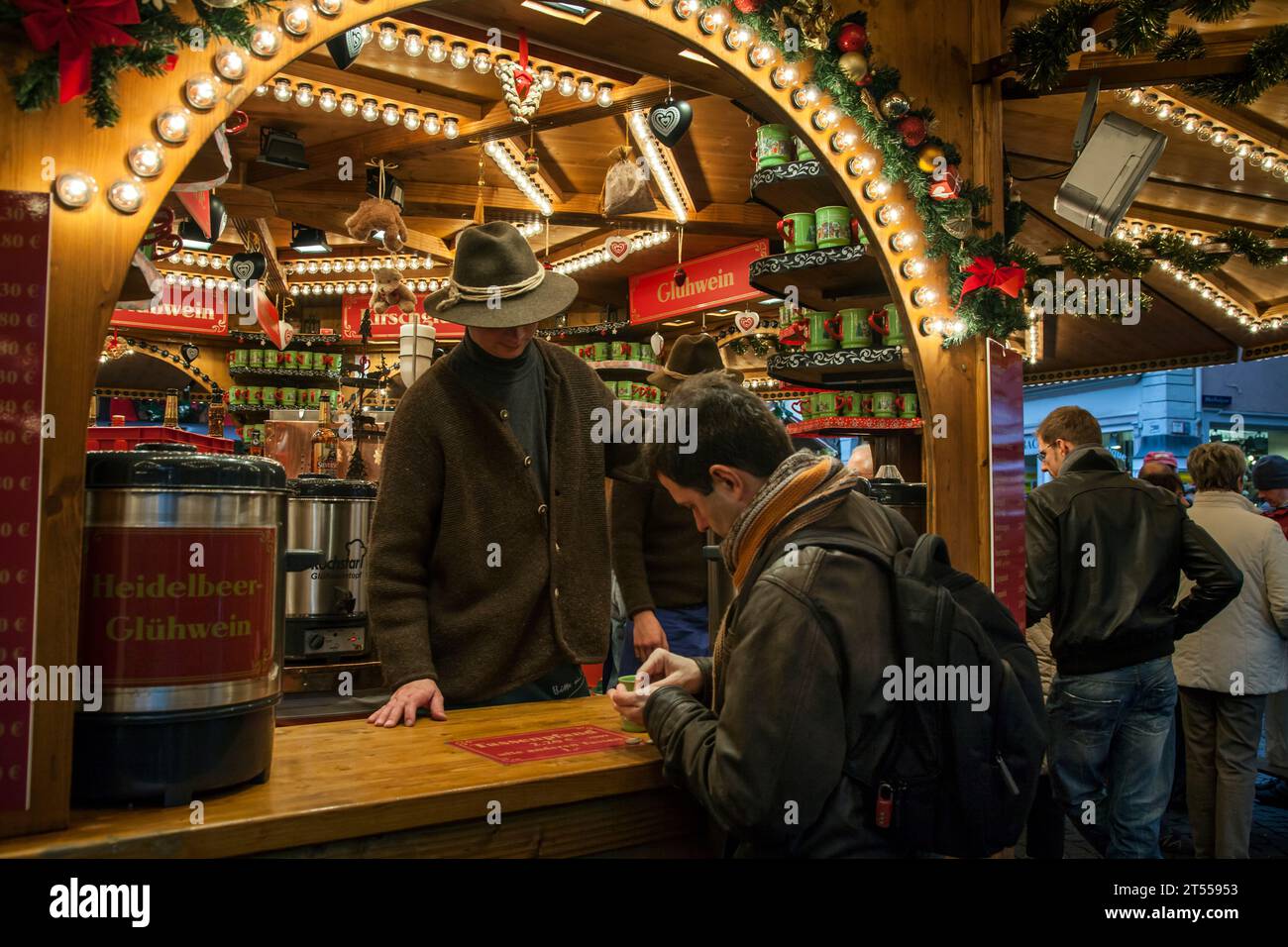 Cliente che paga il suo drink in una bancarella di legno glühwein al mercato di Natale Marktplatz di Heidelberg Foto Stock