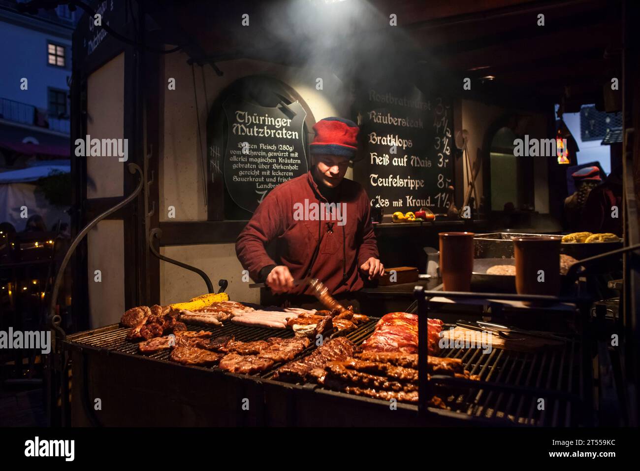 Vista notturna di una bancarella di carne arrostita nel mercato di Natale di Mittelalter, Dresda Foto Stock