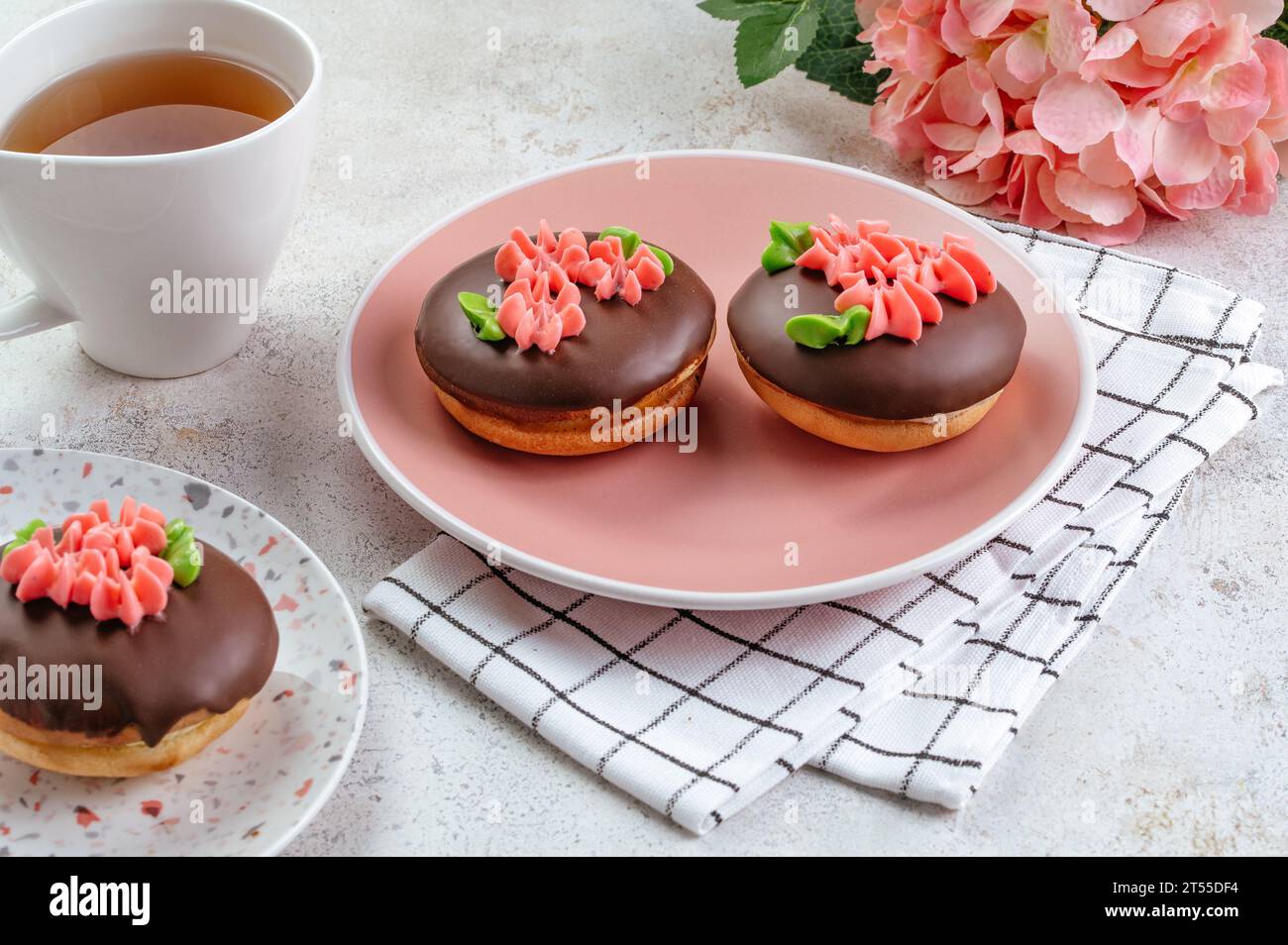 torta al cioccolato decorata con fiori di panna Foto Stock