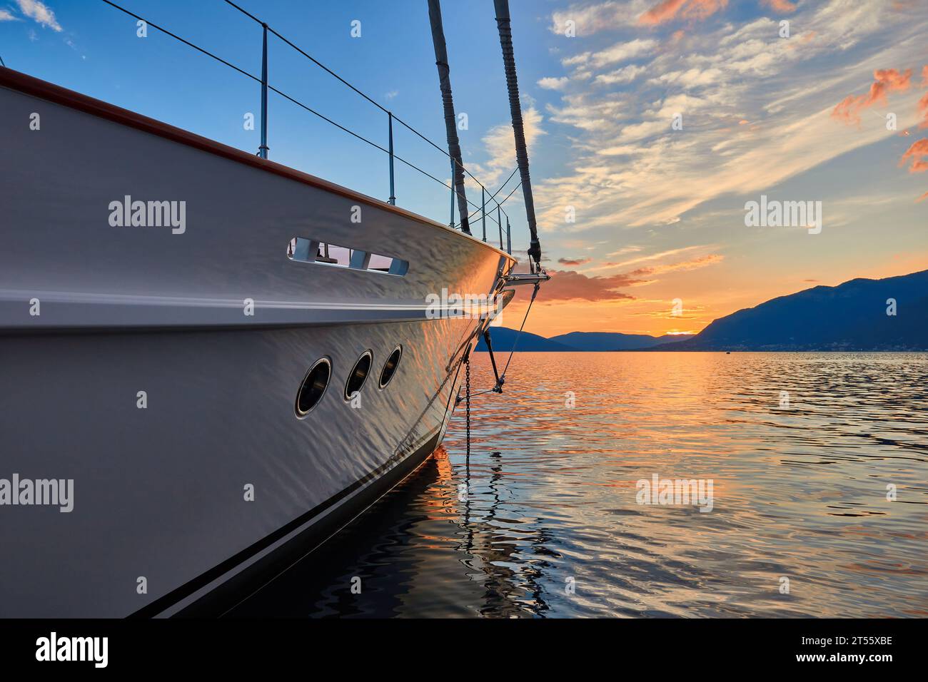 Yacht a vela di 35 metri al tramonto nella baia del Montenegro con colline sullo sfondo. Foto Stock