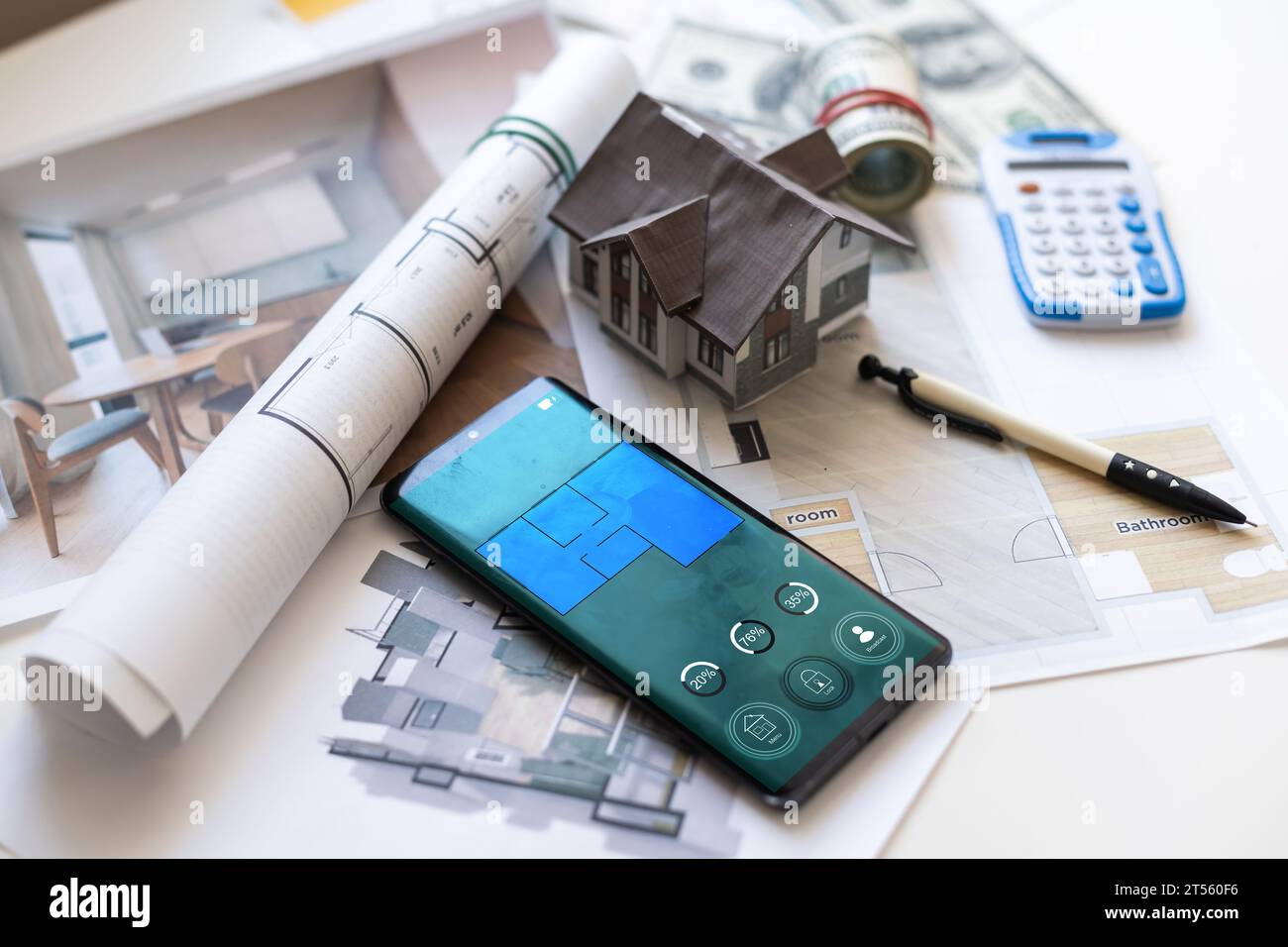 Alcune banconote in euro, una calcolatrice e una chiave di casa in cima ai piani di costruzione. Foto Stock