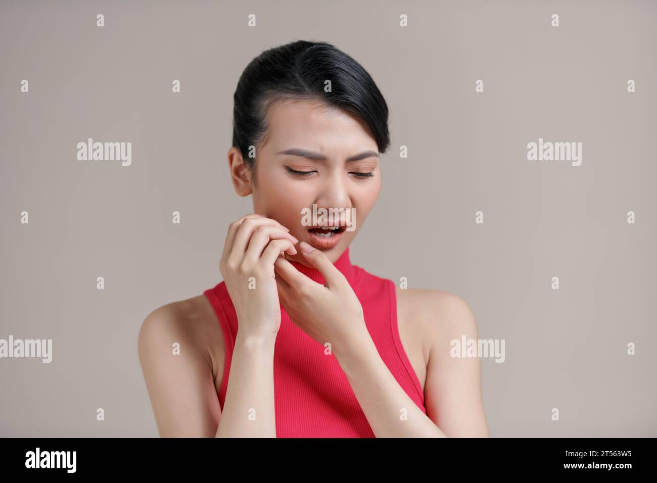 Donna asiatica che preme la guancia con un'espressione dolorosa come se avesse un terribile mal di denti Foto Stock
