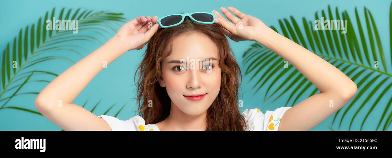 Primo piano volto fresco di una bella ragazza asiatica con piante verdi. Banner Foto Stock
