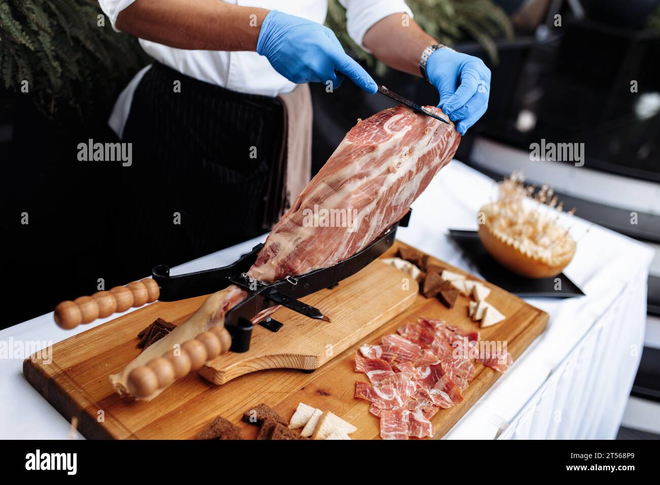 Vista laterale di una fresa professionale che taglia le fette da un inceppamento. Piatti mediterranei, specialità gastronomiche. Foto Stock