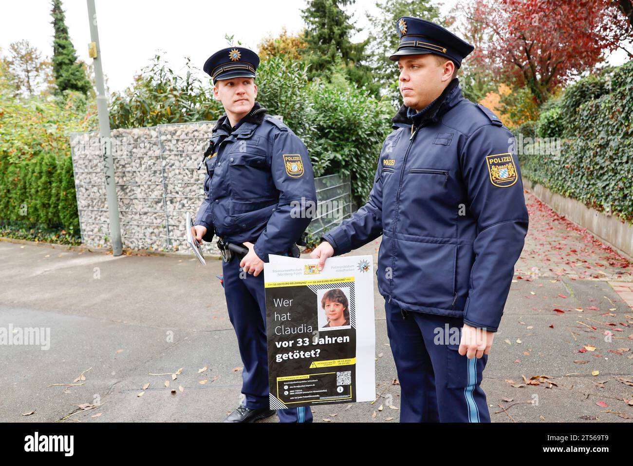 3 novembre 2023, Baviera, Röthenbach an Der Pegnitz: Gli agenti di polizia tengono volantini e la polizia riapre le indagini sul caso freddo di Claudia Obermeier dopo più di 30 anni. Gli investigatori hanno nuove piste e stanno riaprendo l'indagine dopo più di 33 anni. Il ventiduenne è stato vittima di un omicidio nell'agosto 1990 a Röthenbach an der Pegnitz, nella Franconia centrale. Foto: Daniel Löb/dpa Foto Stock