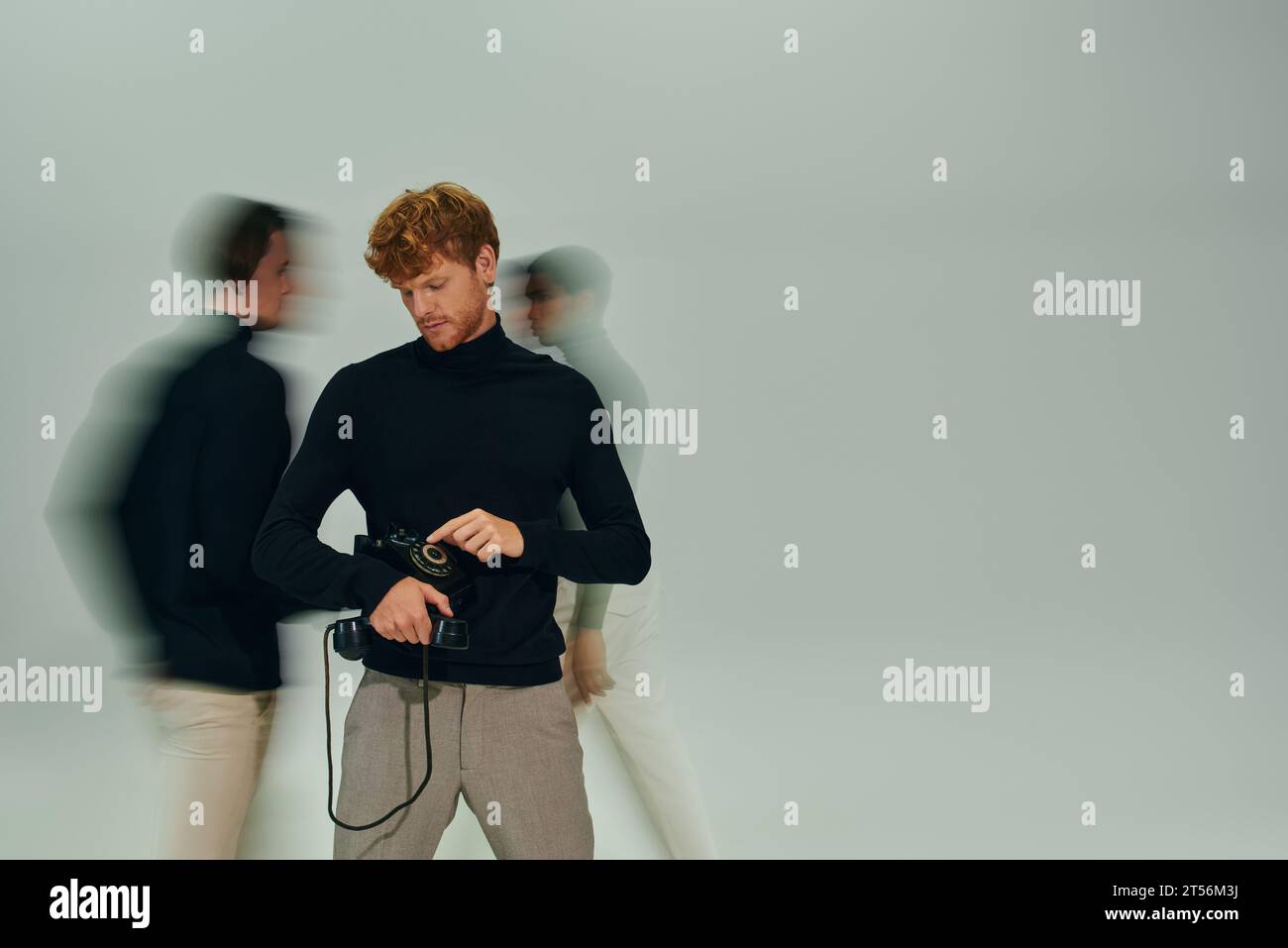 foto a lunga esposizione di un trio multiculturale in dolcevita nera con telefono retrò, uomini power Foto Stock