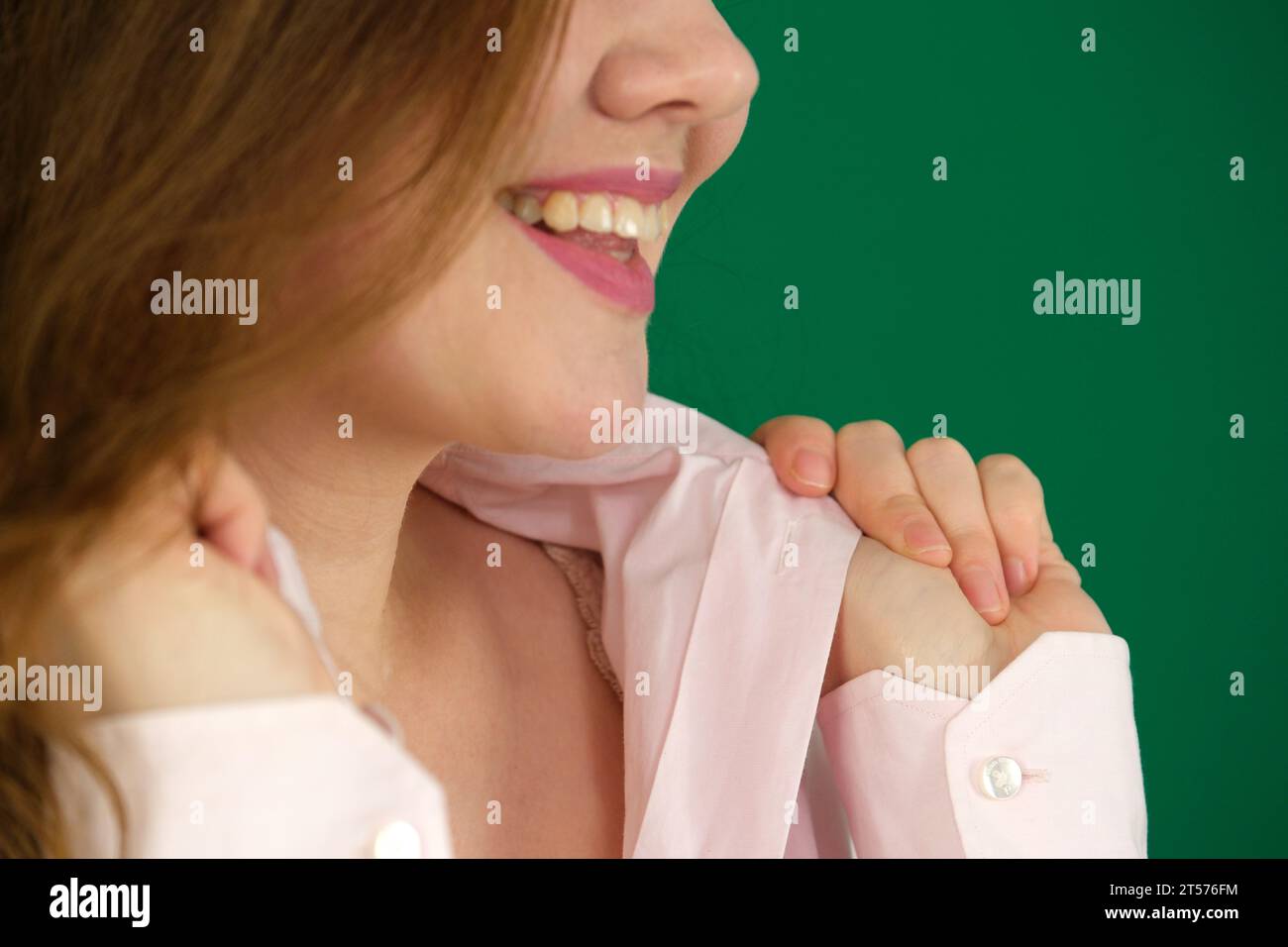 Giovane donna che indossa una camicia bianca che regge il colletto. Foto di alta qualità Foto Stock