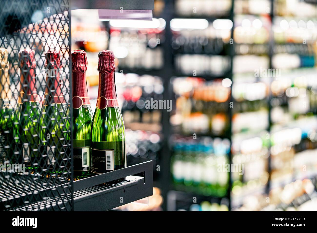 Vino frizzante sullo scaffale del negozio di alcolici. Bottiglia di champagne esposta nel negozio di alcolici. Sezione bevande del supermercato. Sconto economico o prezzo costoso. Foto Stock