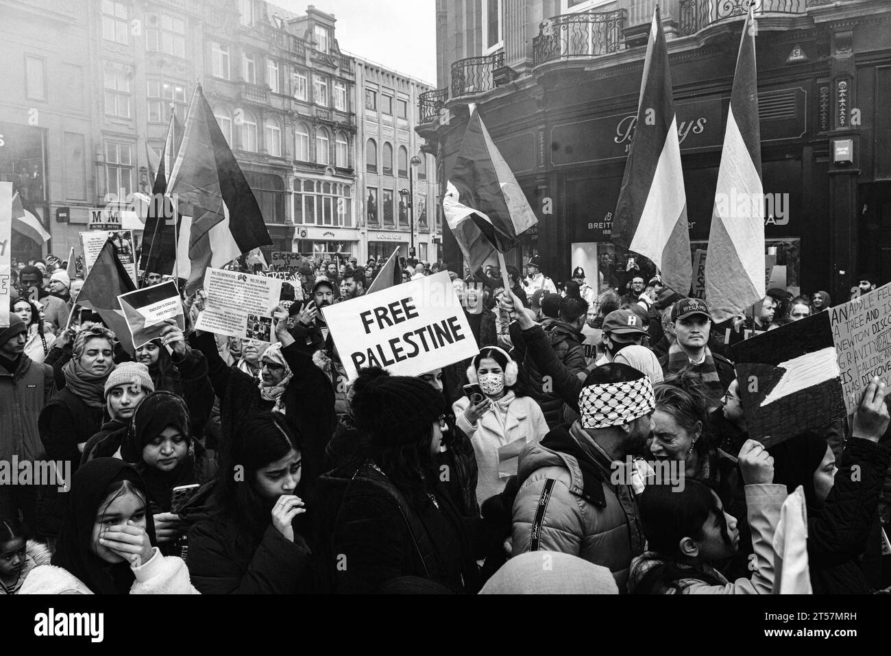 La folla di manifestanti marcia per il cessate il fuoco di Gaza sventolando bandiere palestinesi e cartelli per la Palestina libera al Grey's Monument. Newcastle 28, 2023. Bianco e nero. Foto Stock