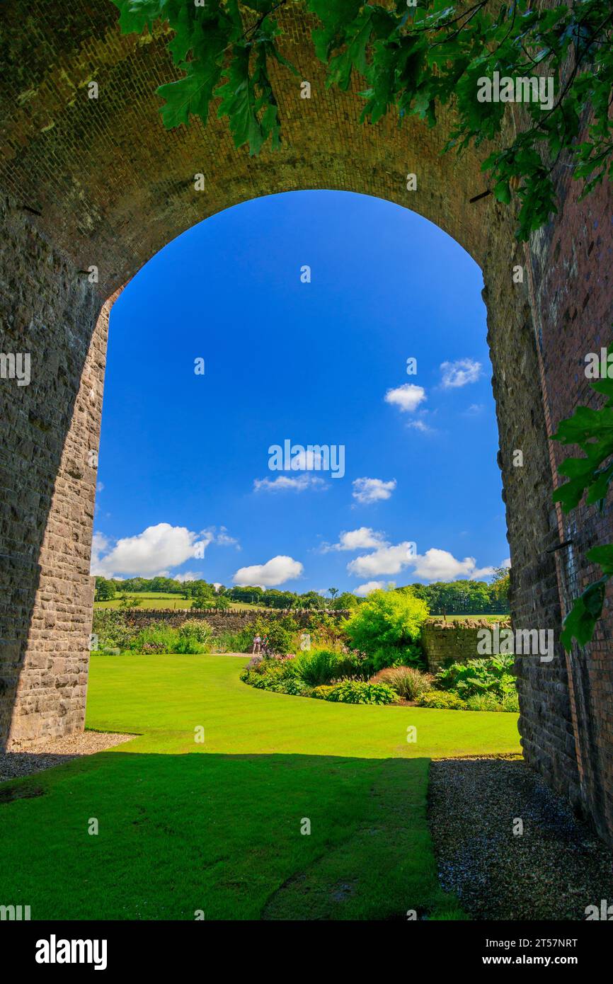Un attraente confine erbaceo sotto il viadotto ferroviario in disuso a Kilver Court Gardens, Shepton Mallet, Somerset, Inghilterra, Regno Unito Foto Stock