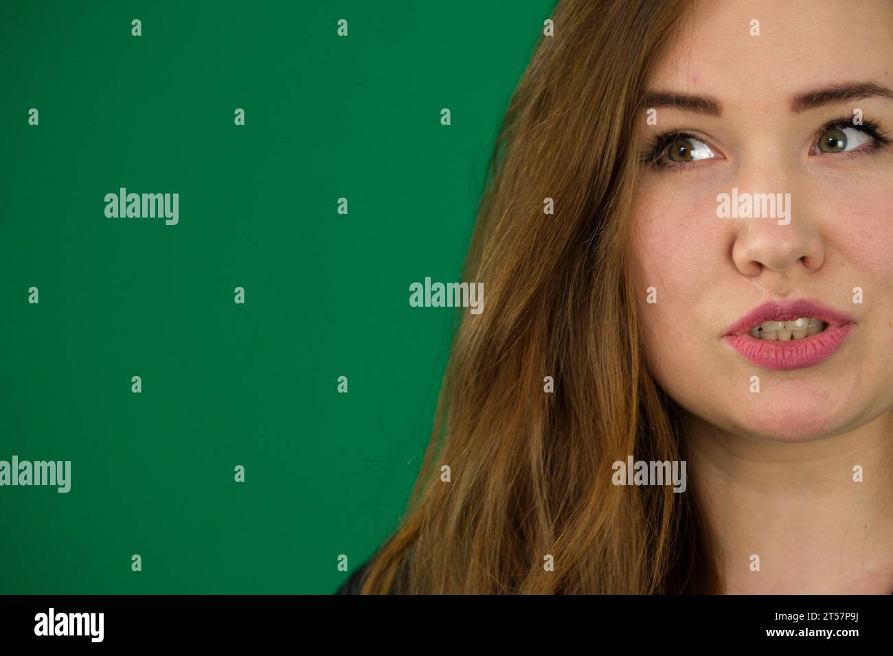 donna su sfondo verde cromakey con una camicia da uomo a righe nere emozioni diverse espressione facciale primo piano spazio pubblicitario per la pulizia del testo. occhi gentili Foto Stock