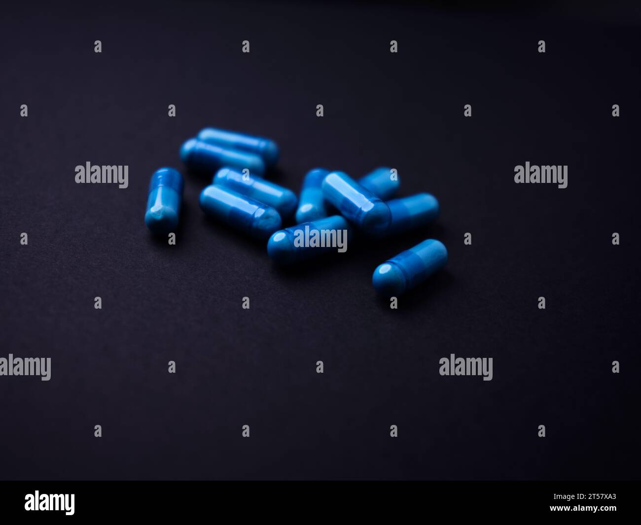 Capsule di aminoacidi su sfondo di carta scura. Messa a fuoco morbida. Primo piano. Copia spazio. Foto Stock