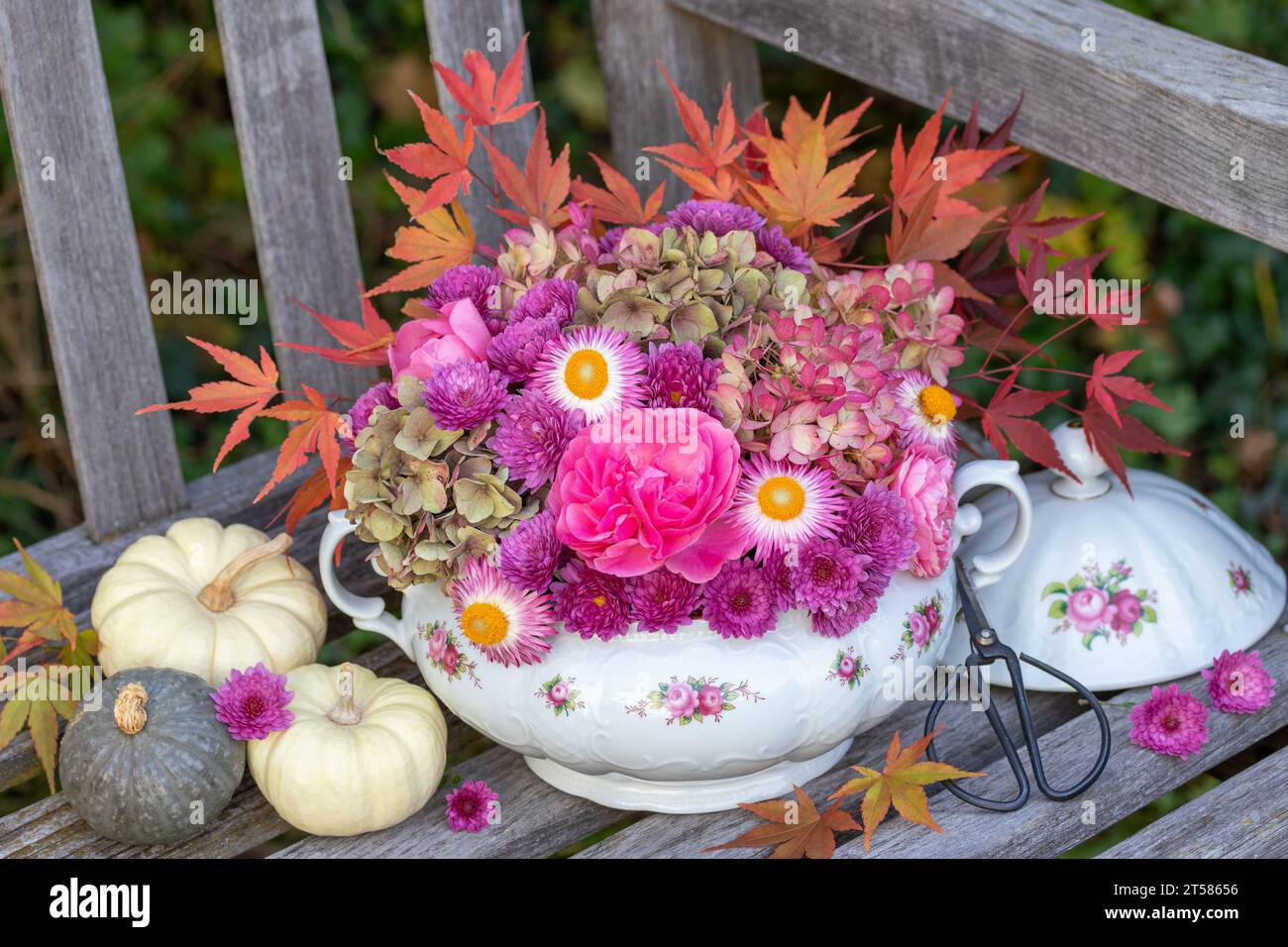 composizione floreale di rose rosa, fiori di ortensia, crisantemi e foglie d'acero in zuppa di tureen vintage Foto Stock